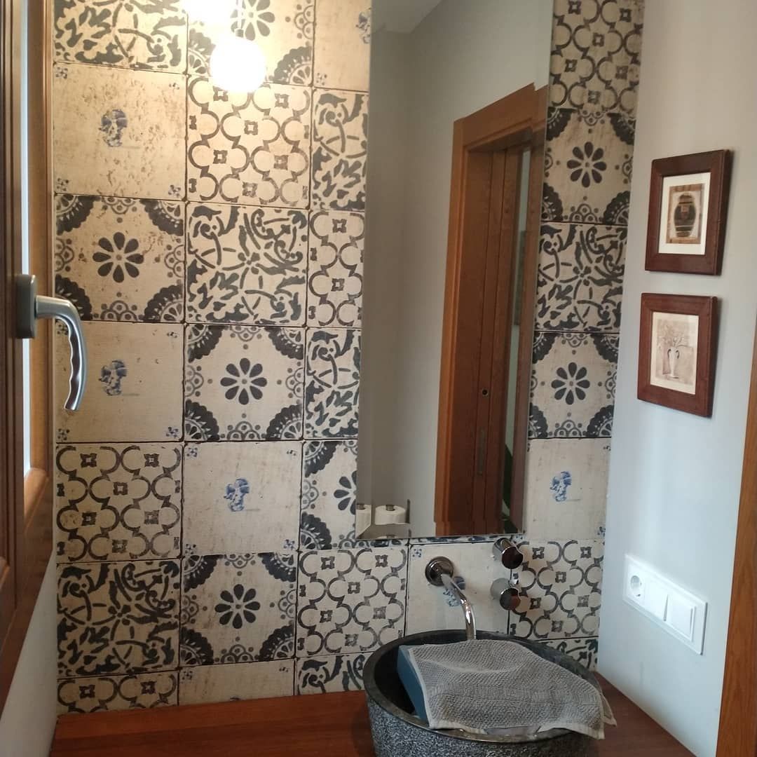 Un baño con azulejos blancos y negros y un lavabo.