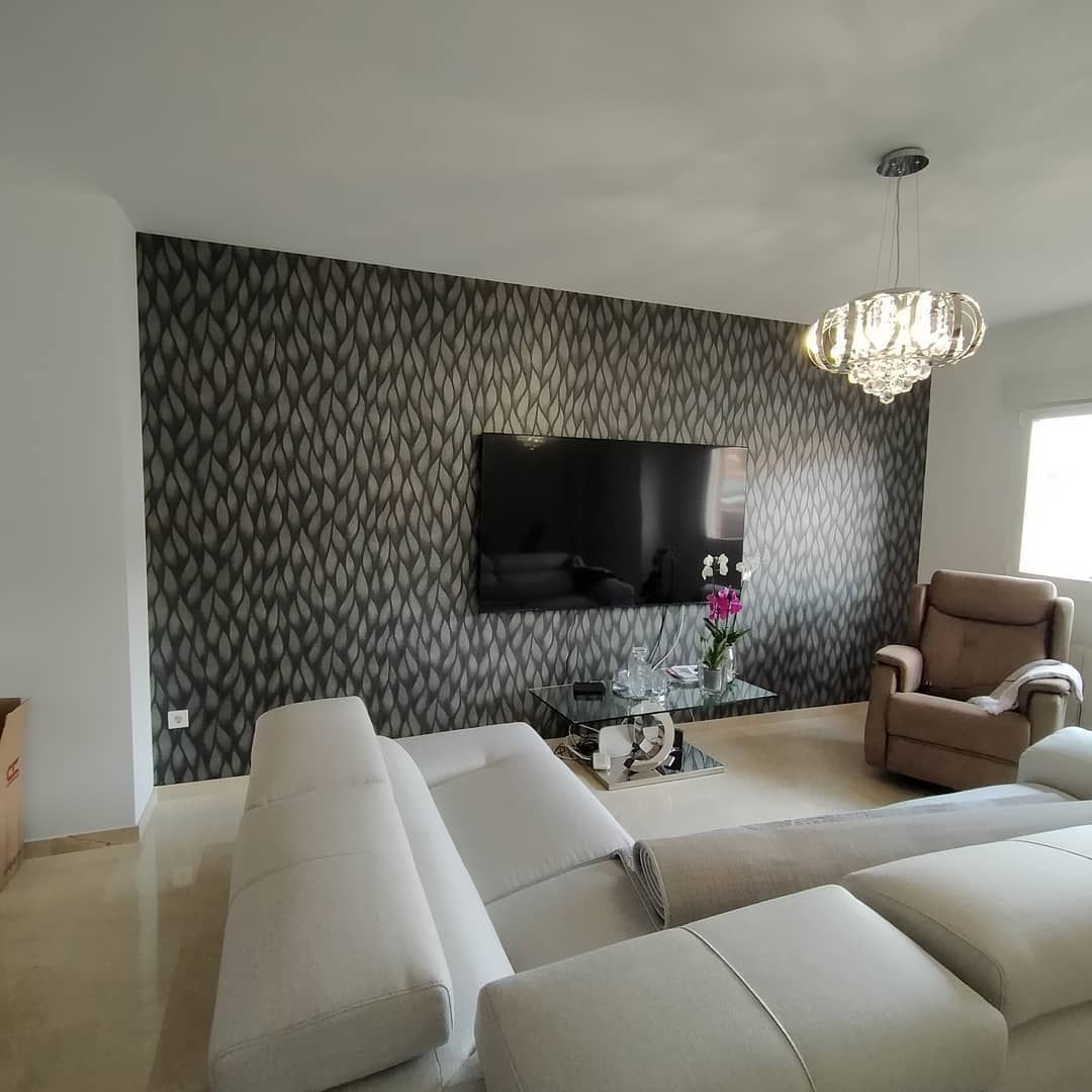 Una sala de estar con un televisor de pantalla plana grande en la pared.