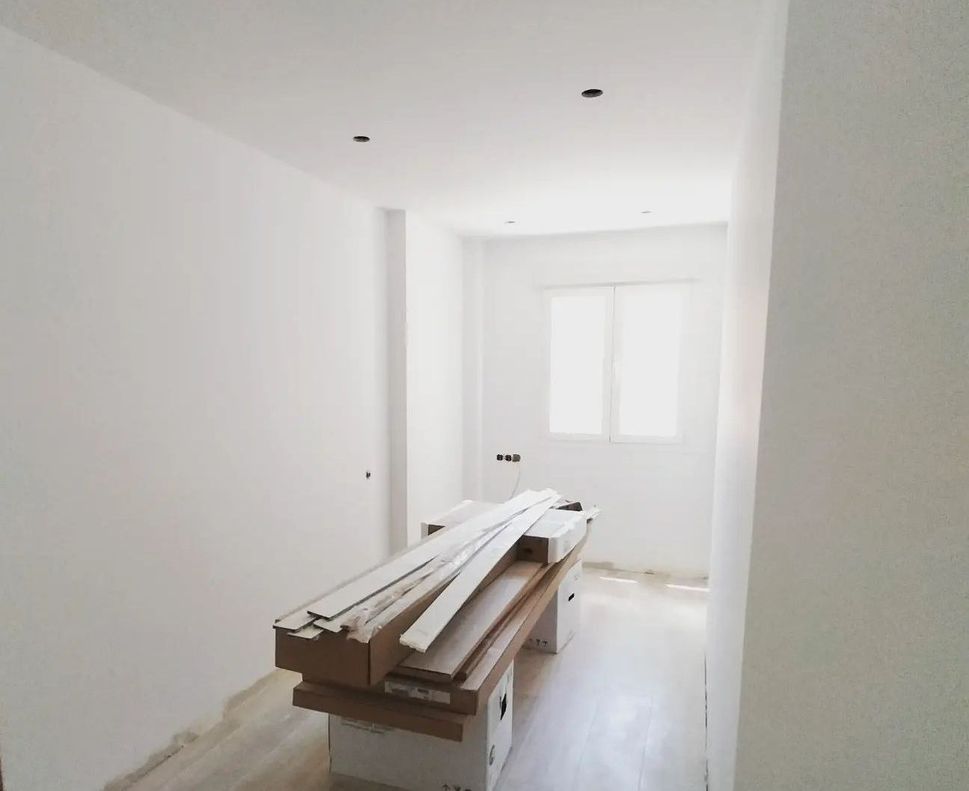 Una habitación vacía con una pila de madera en el suelo