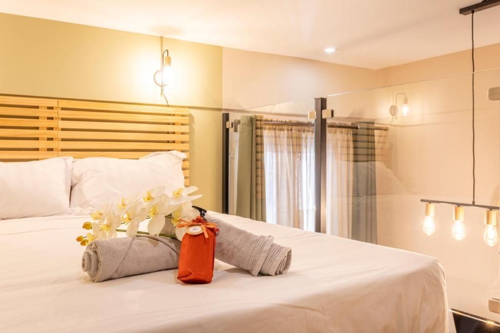 Une chambre d'hôtel avec un lit, des serviettes et des fleurs dessus.