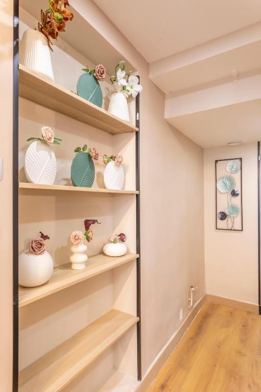 Un couloir avec des étagères remplies de vases et de fleurs