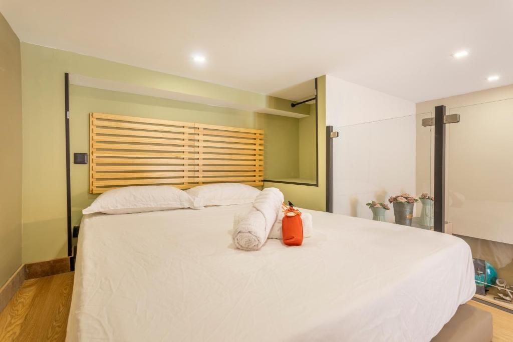 Une chambre avec un grand lit et une tête de lit en bois.