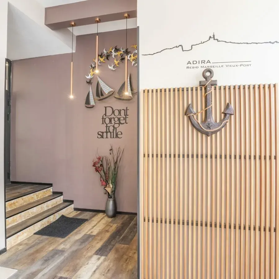 Couloir moderne avec une pancarte murale « N'oubliez pas de sourire », une décoration sur le thème des bateaux, un extincteur rouge et un mur en lattes de bois.