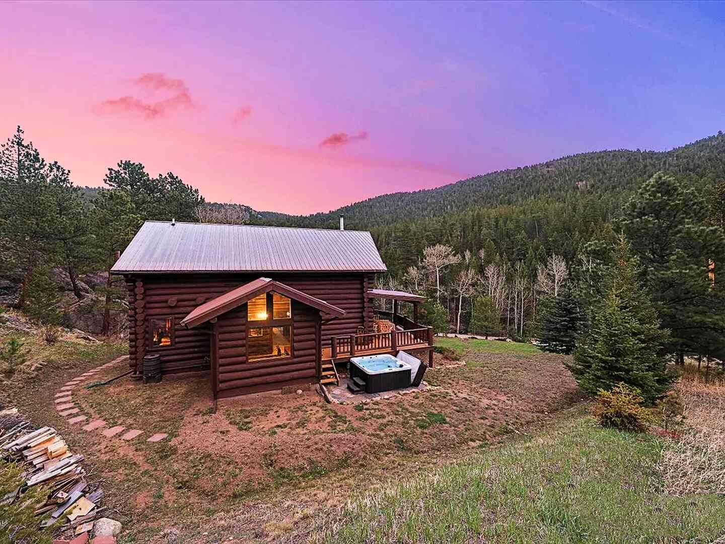 The Riverside Cabin at twilight, a log cabin with hot tub and mountain views in Allenspark, Colorado