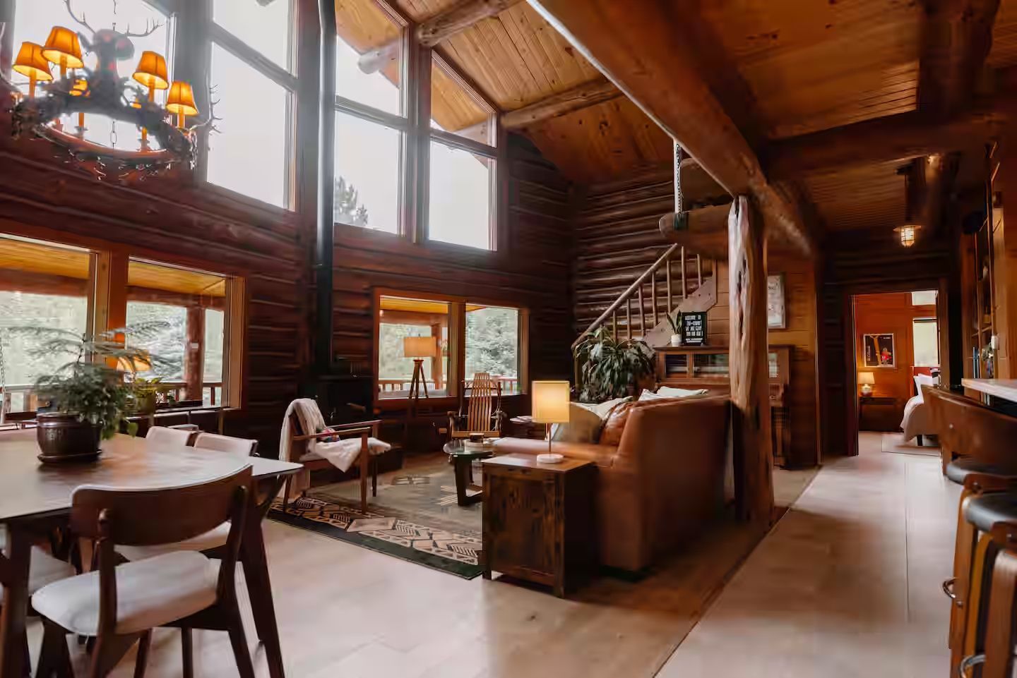 Great room with dining and living areas under cathedral windows at The Riverside Cabin