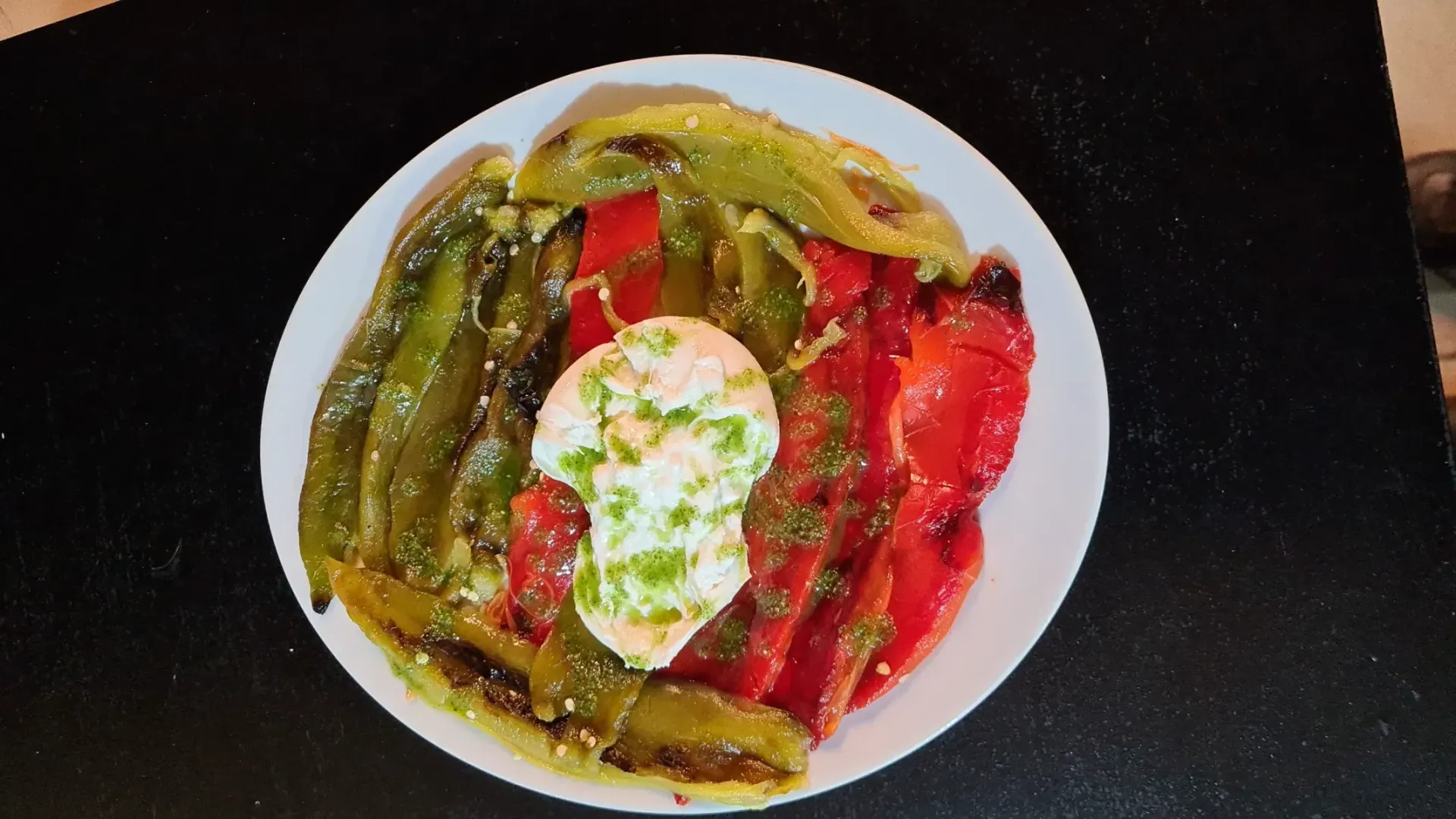 Un plato blanco cubierto con verduras y un huevo frito.