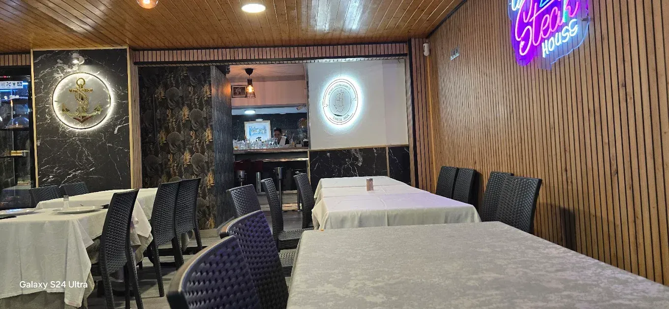 Interior de un restaurante con mesas, sillas y paneles de pared decorativos.