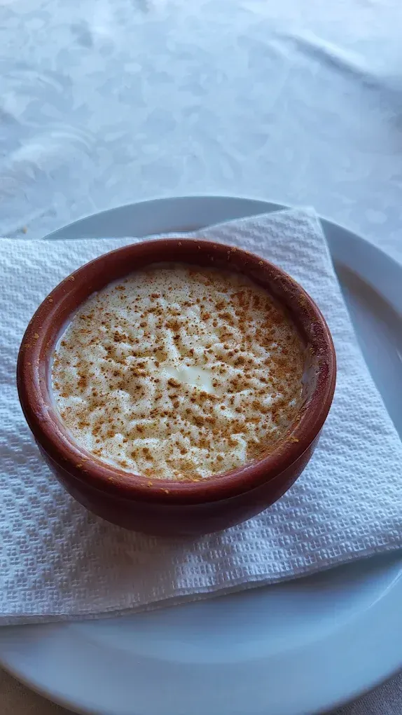 Almejas abiertas en un plato; carne roja y naranja, conchas blancas.