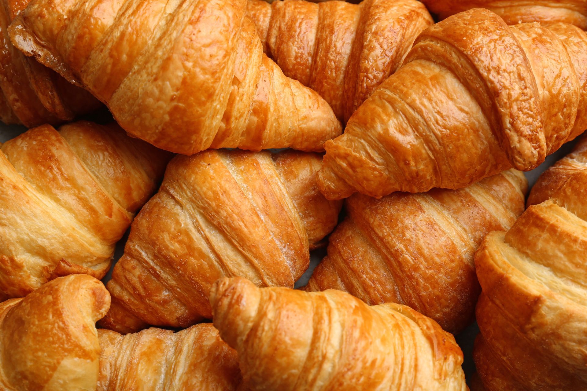 Auf einem Tisch liegt ein Stapel Croissants übereinander.