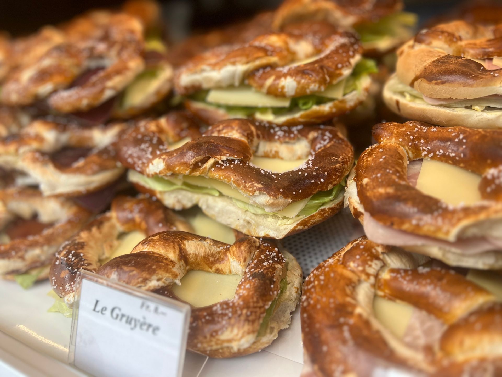 Ein Haufen Brezeln mit Sandwiches darauf in einer Vitrine.