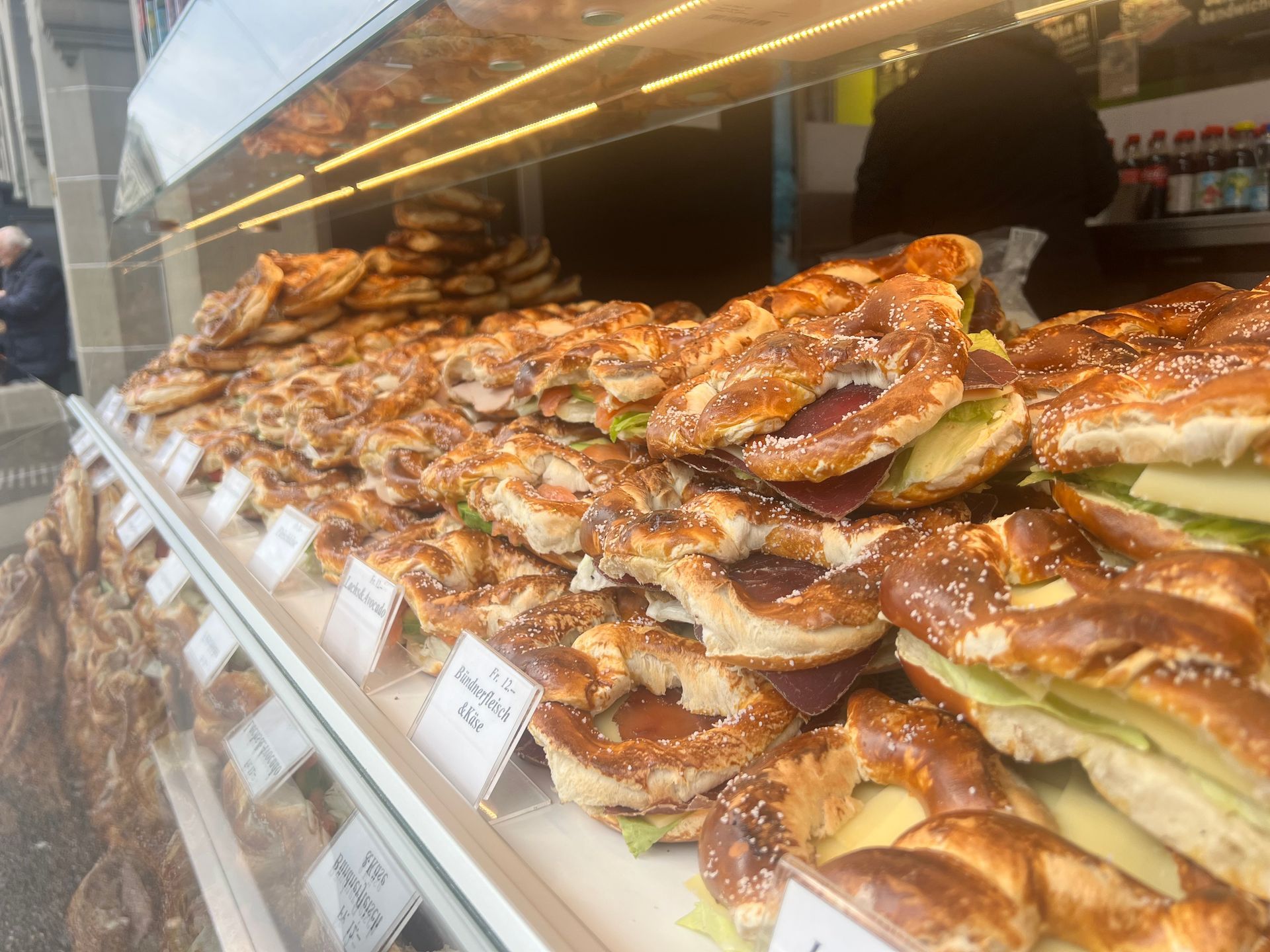 Eine Vitrine voller Brezeln und Sandwiches in einer Bäckerei.