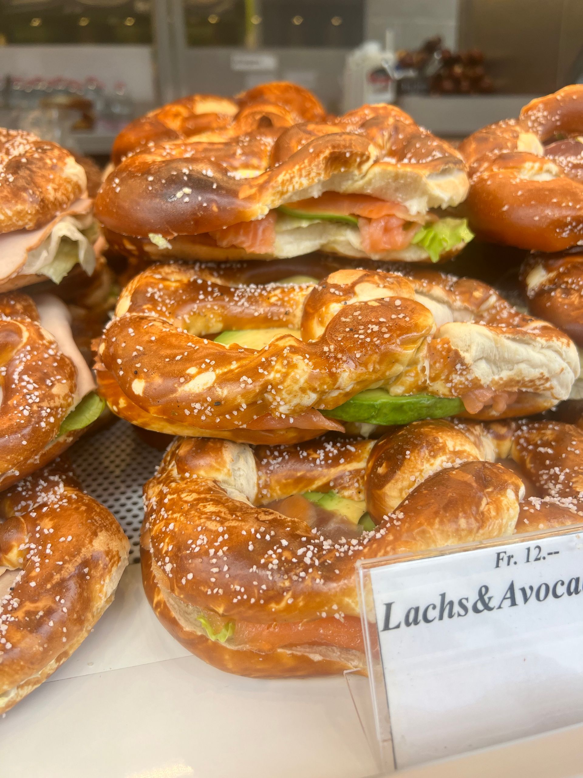 Auf einem Tisch sind mehrere Brezeln mit Sandwiches darauf übereinander gestapelt.