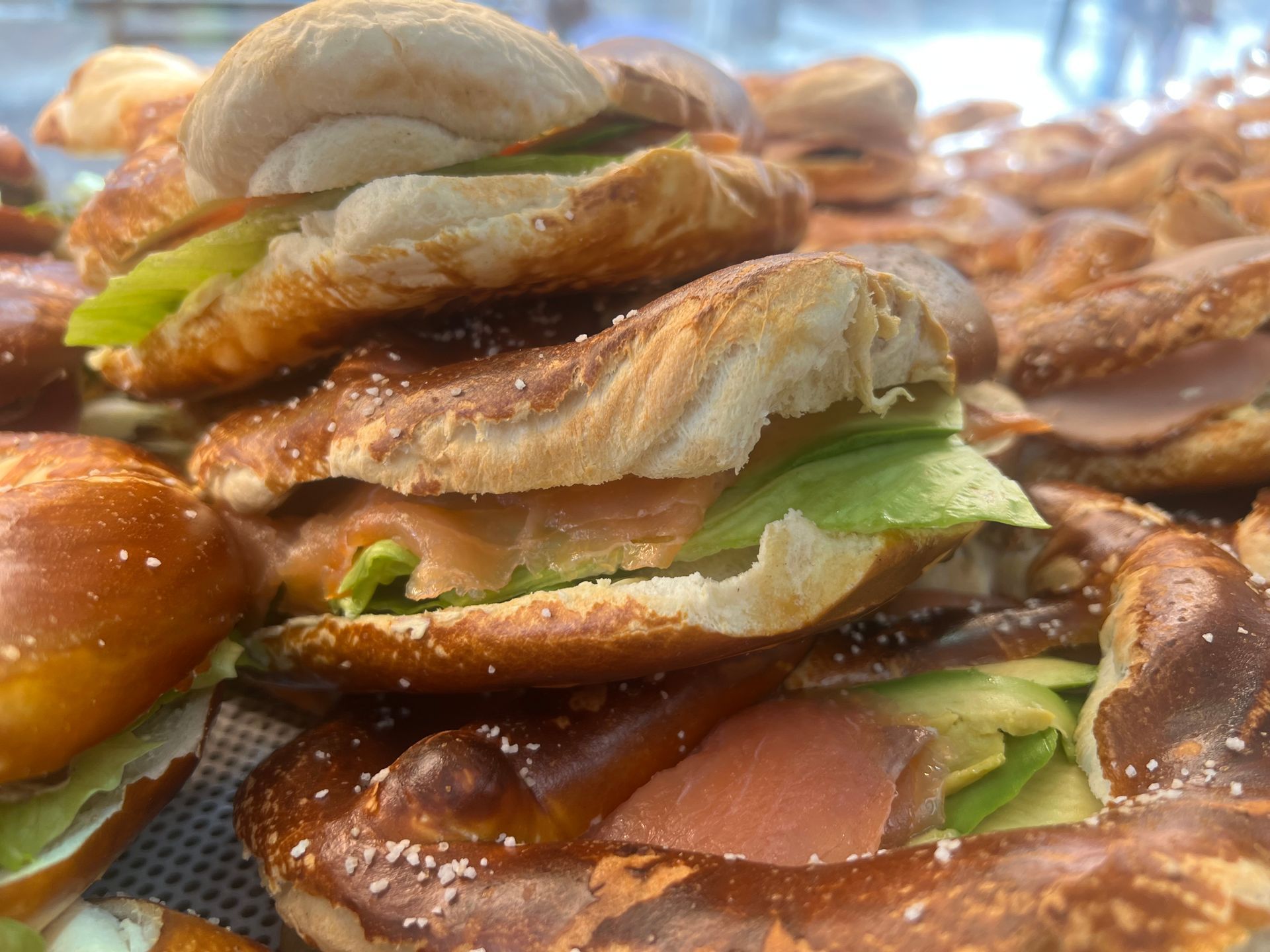 Auf einer Brezel liegt ein Sandwich.