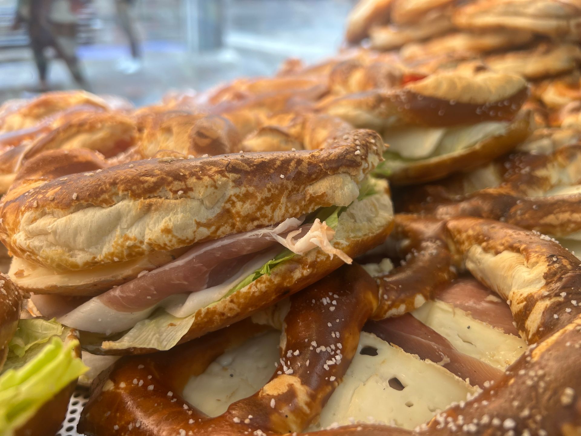 Auf einer Brezel liegt ein Sandwich.