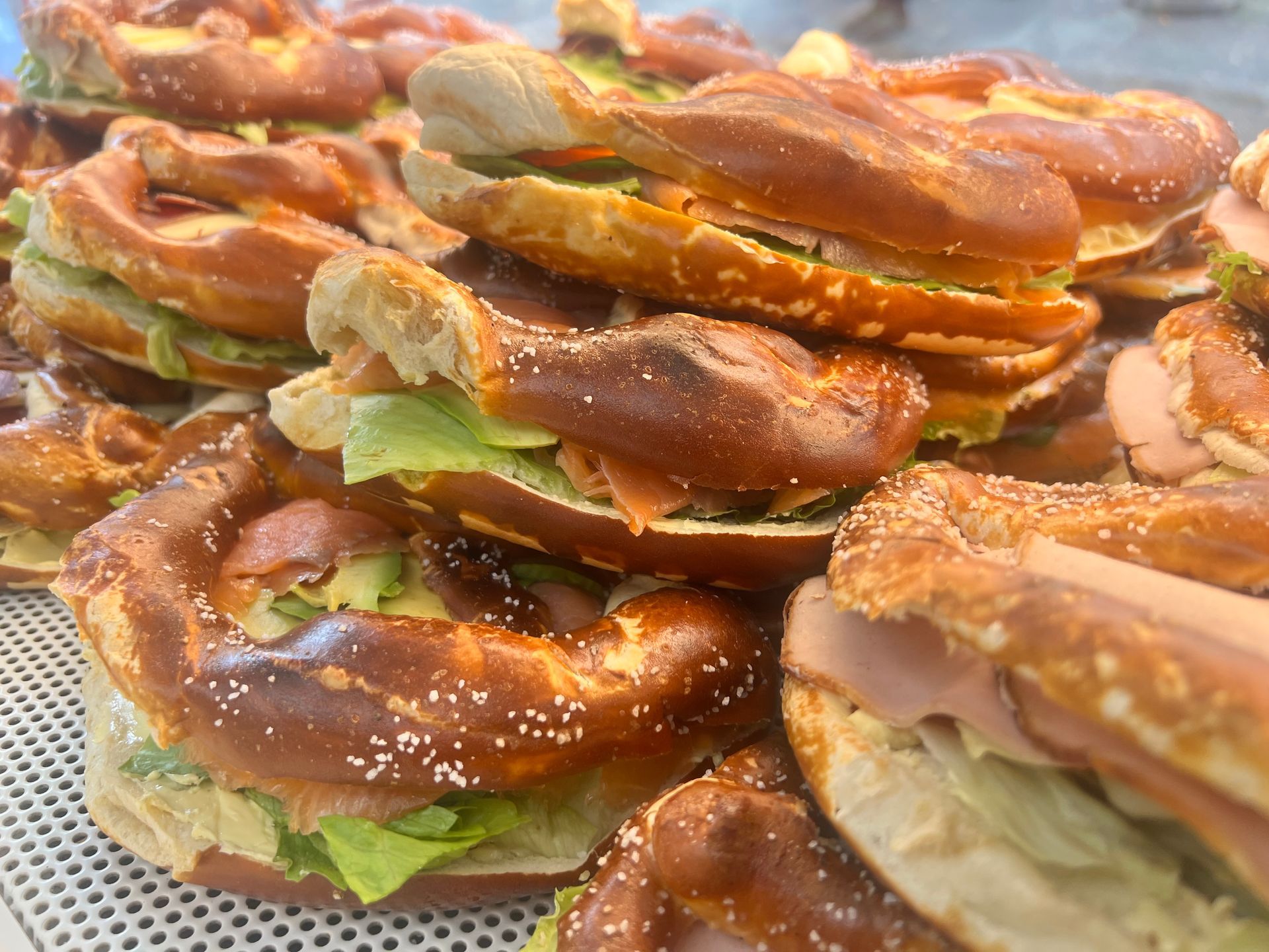 Ein Haufen Brezeln mit Sandwiches darauf auf einem Tisch.