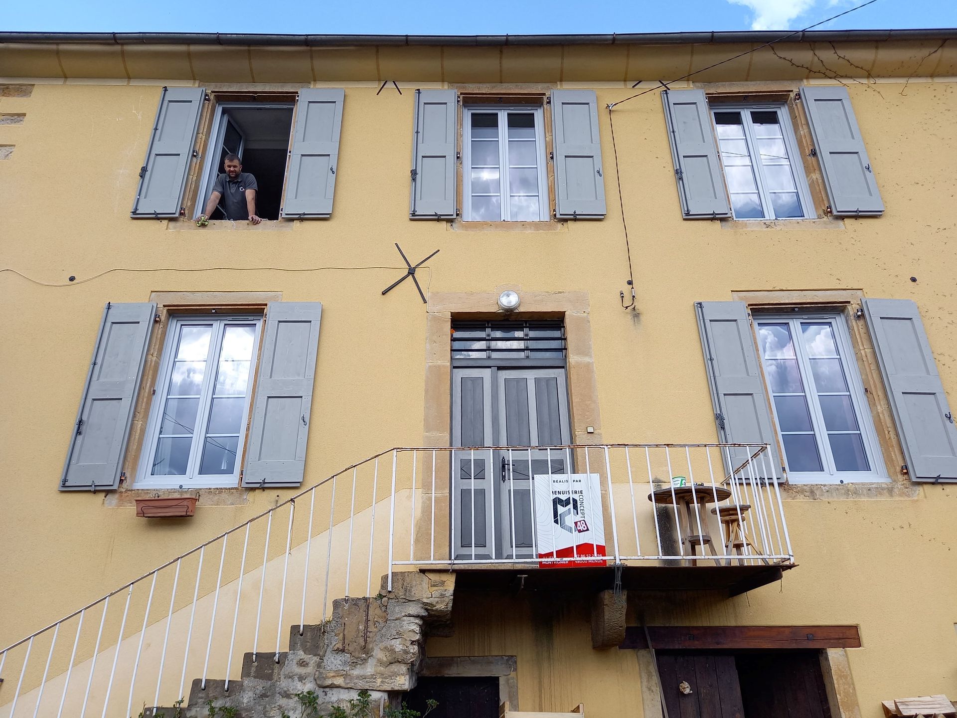 Pose de volets bleus en bois.