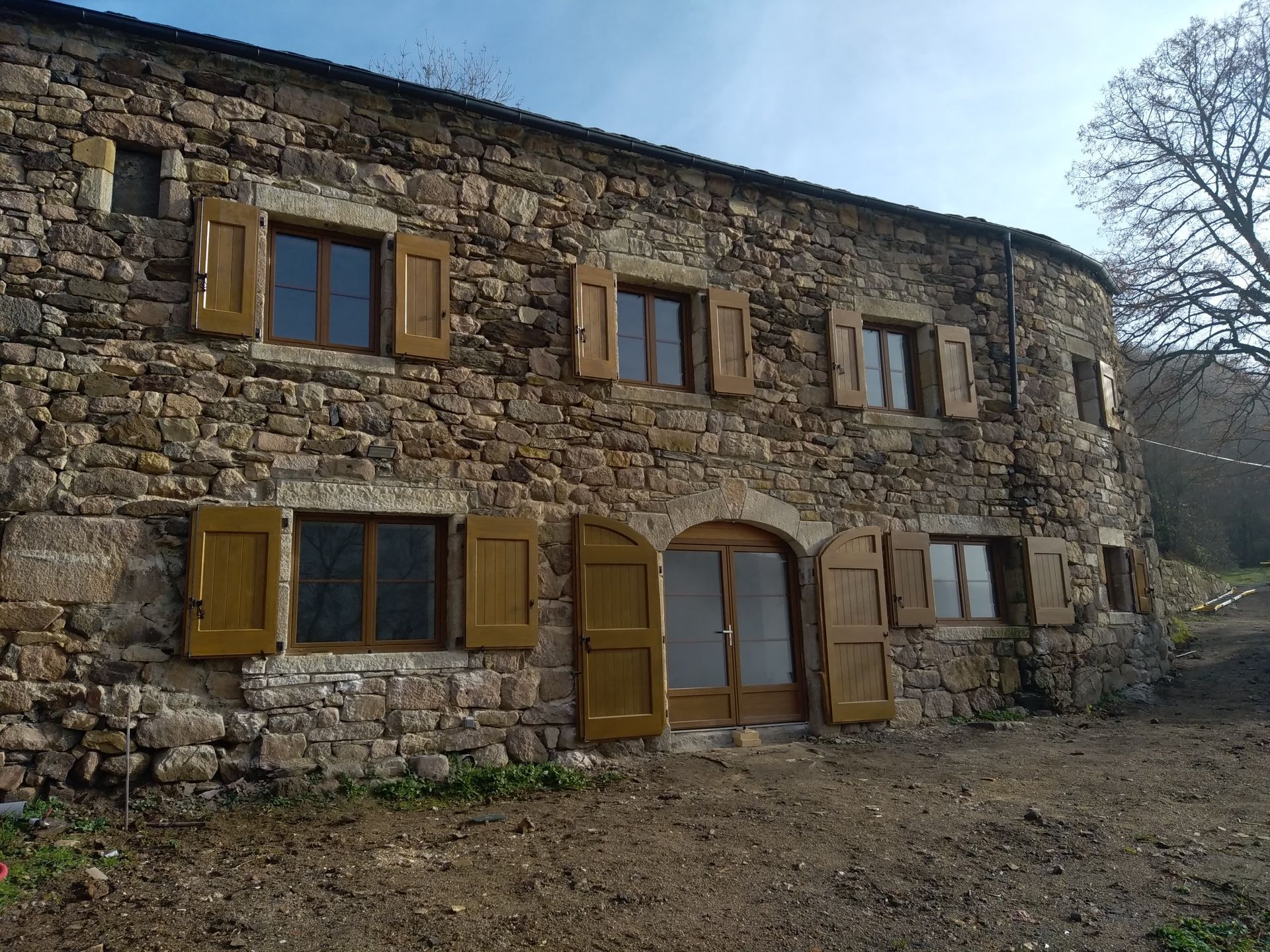 Volets en bois sur une maison en pierre.