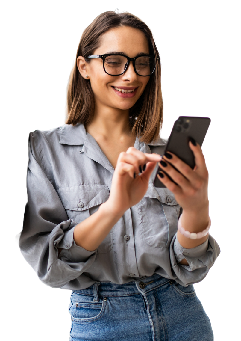 Jeune femme à lunettes et souriante vêtue d'un chemisier gris regardant le téléphone qu'elle tient dans ses mains