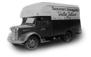 Fourgonnette de livraison noire vintage avec texte publicitaire sur le côté, vue de profil.