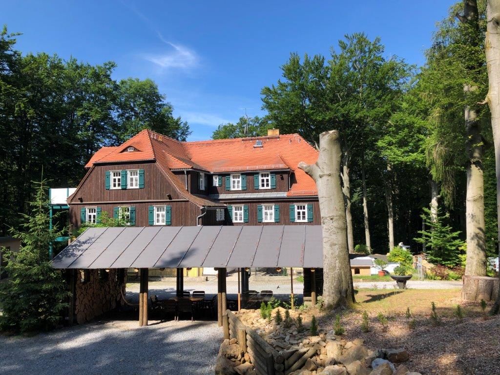 Historisches Gebäude der Familienferienstätte umgeben von Wald und Natur