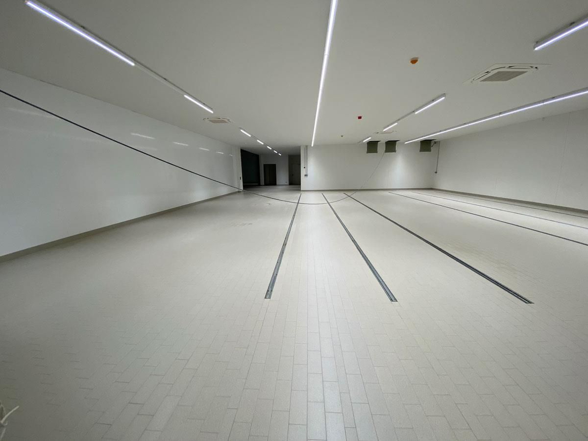 Ein großer leerer Raum mit gefliestem Boden und weißen Wänden