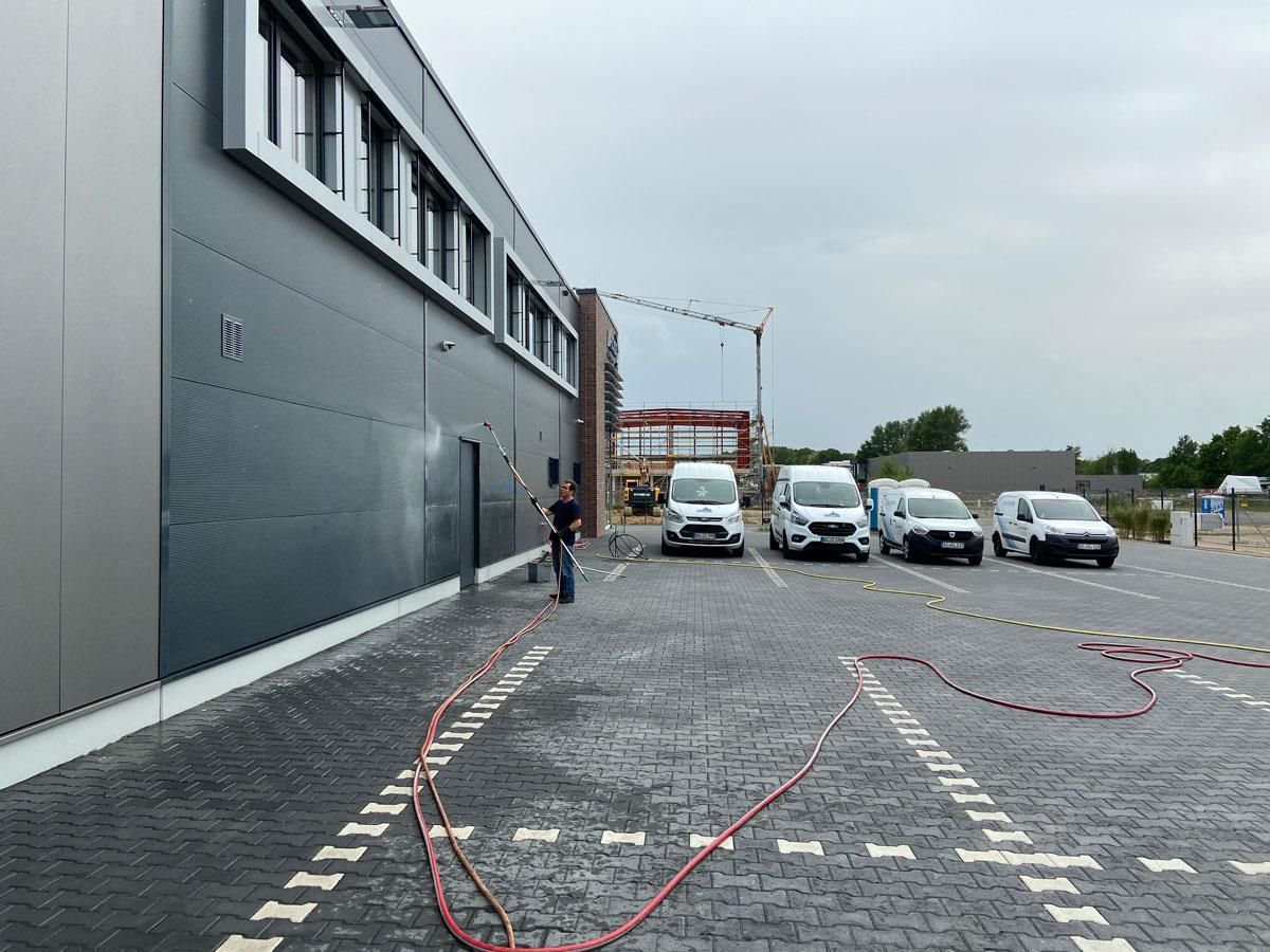 Vor einem Gebäude parkt eine Reihe Lieferwagen.