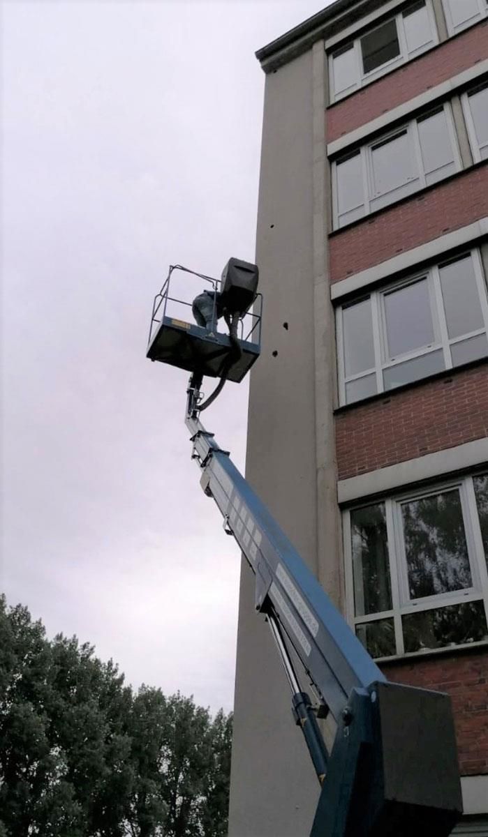 An der Seite eines Gebäudes ist ein Kran befestigt.