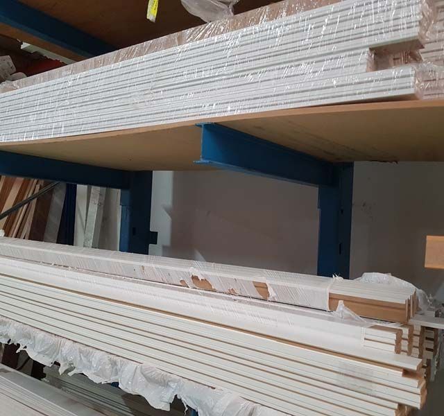 Estantes de molduras blancas envueltas en un entorno de almacén.