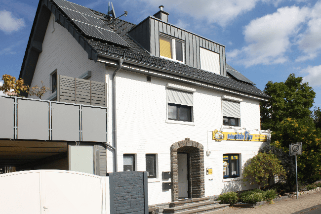 Ein weißes Haus mit einem gelben Schild mit der Aufschrift 