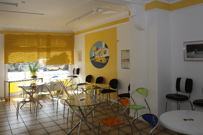 Ein Raum mit Tischen und Stühlen und einem Gemälde an der Wand