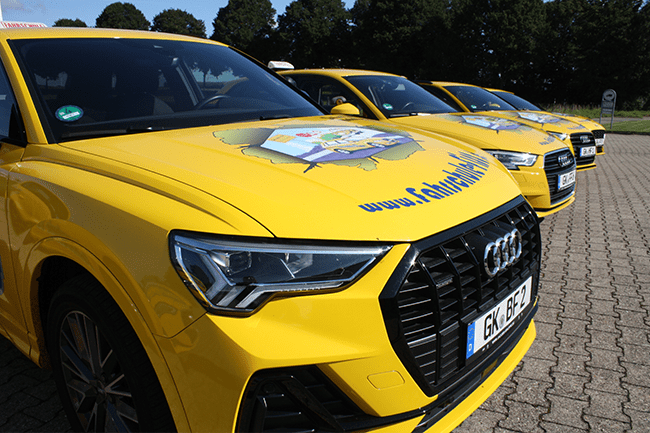 Eine Reihe gelber Audi-Autos steht auf einem Parkplatz