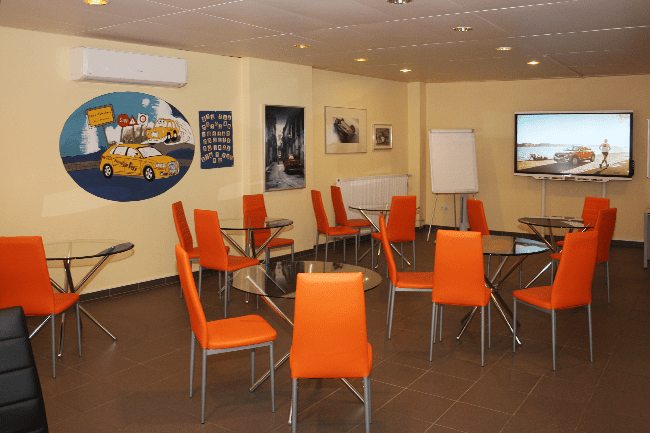 Ein Raum mit Tischen und Stühlen und einem Gemälde eines Taxis an der Wand