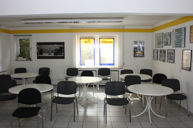 Ein Raum mit Tischen und Stühlen und einem Fenster mit einem Schild mit der Aufschrift „a“ darauf