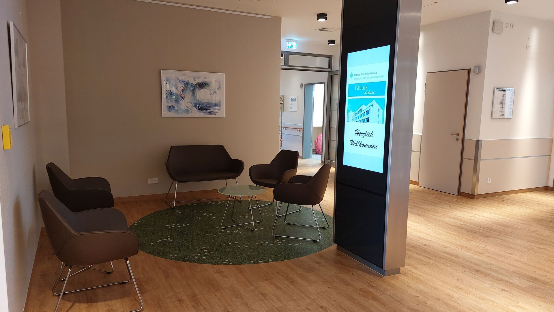 Ein Wartezimmer mit Stühlen, einer Couch und einem Fernseher.