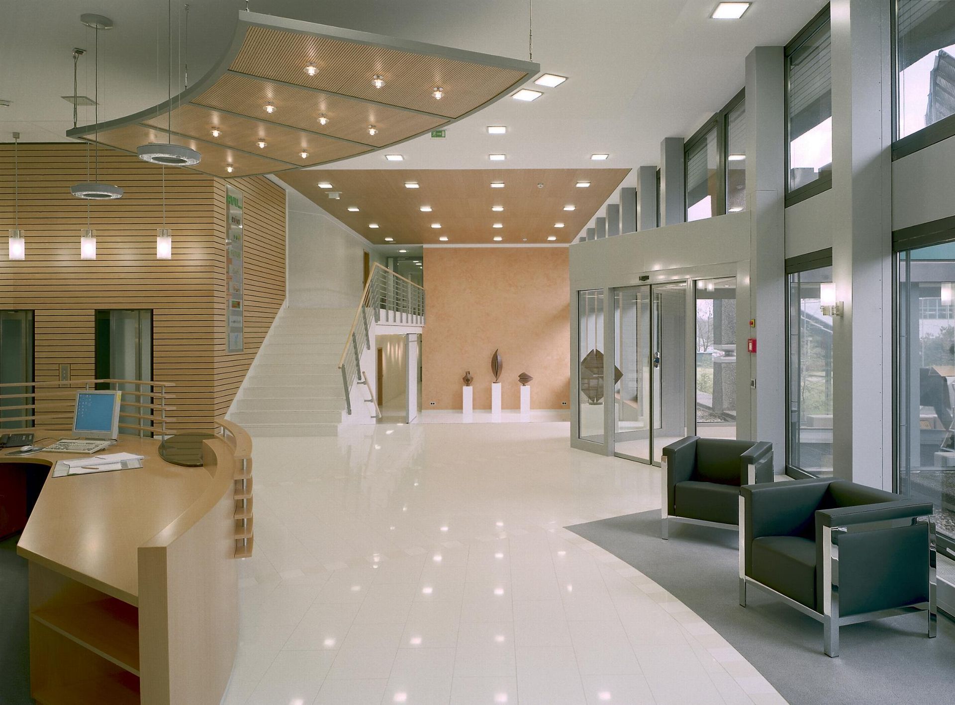 Eine große Lobby mit Schreibtisch, Stühlen und Treppen