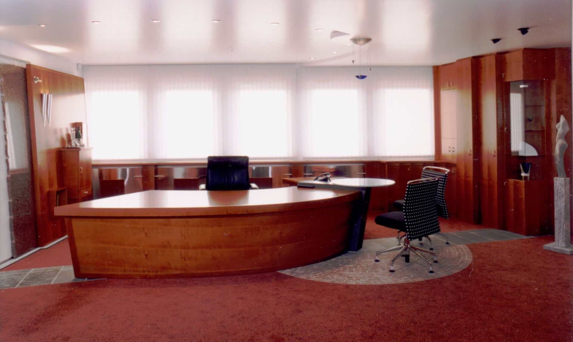 Ein großes Büro mit einem Schreibtisch und Stühlen aus Holz