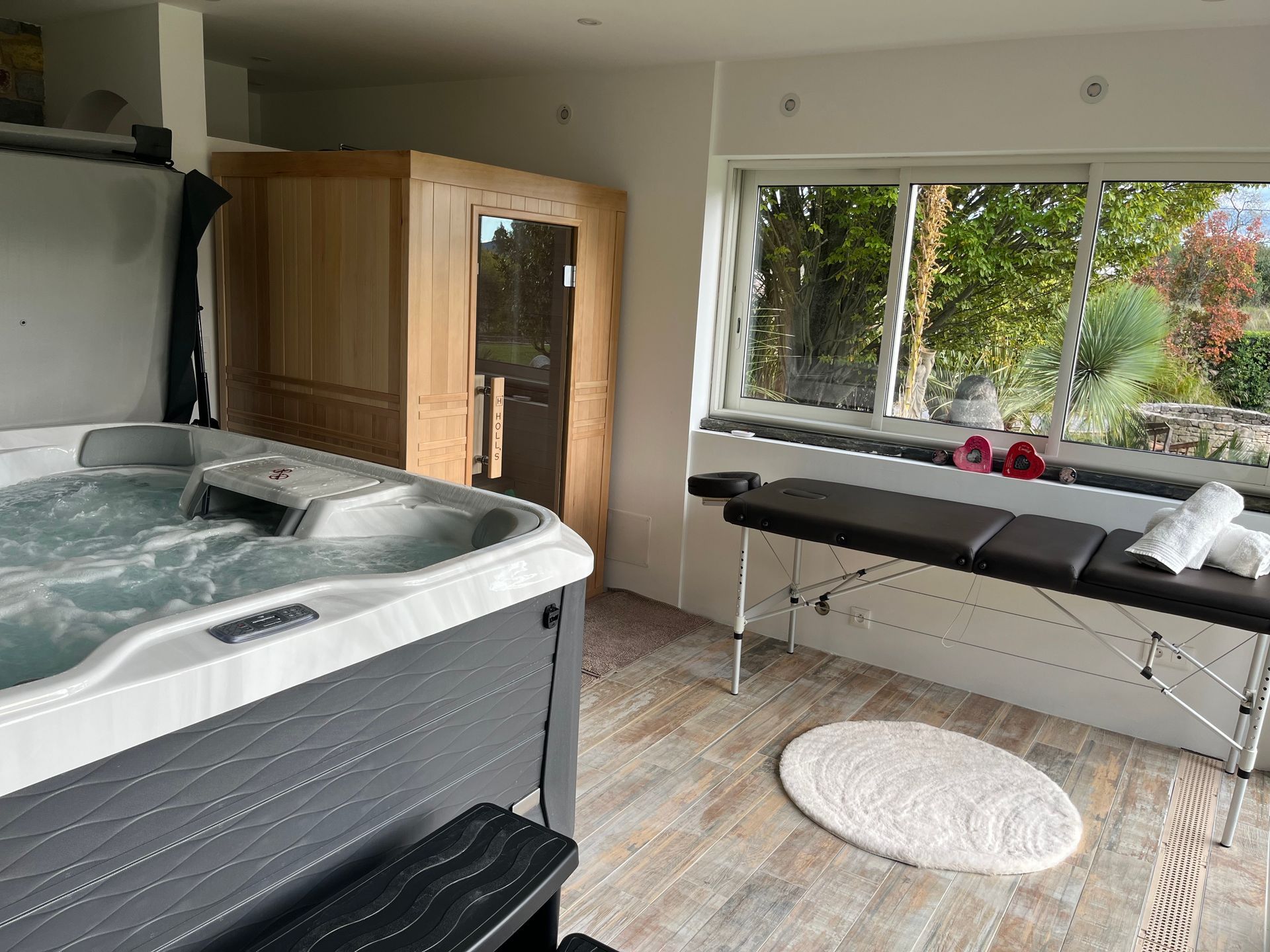 Bain à remous, sauna, able de massage et fenêtre donnant sur la verdure