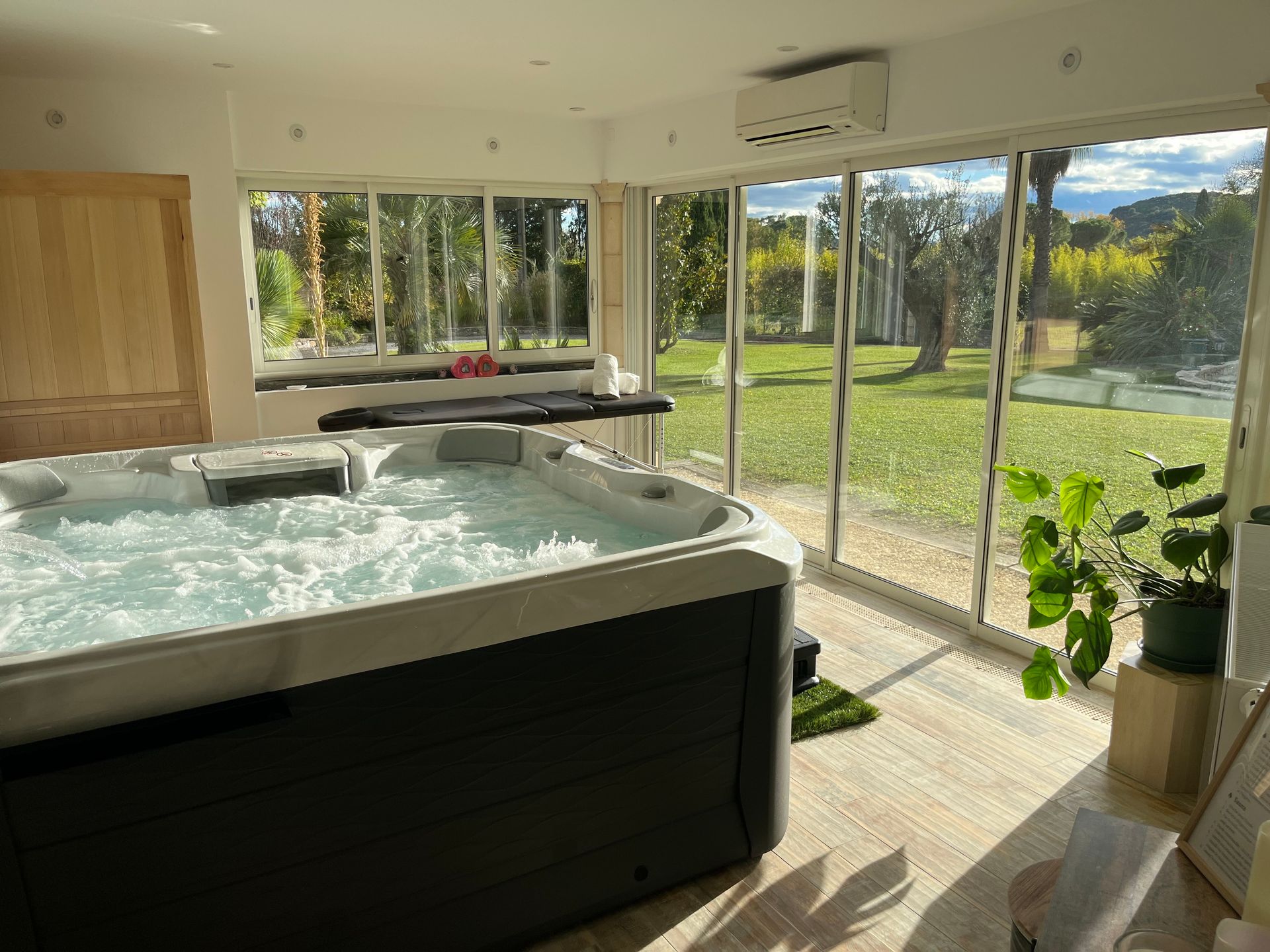 Espace bien être spa sauna table de massage vue sur la piscine et jardin grâce aux grande baies vitrées