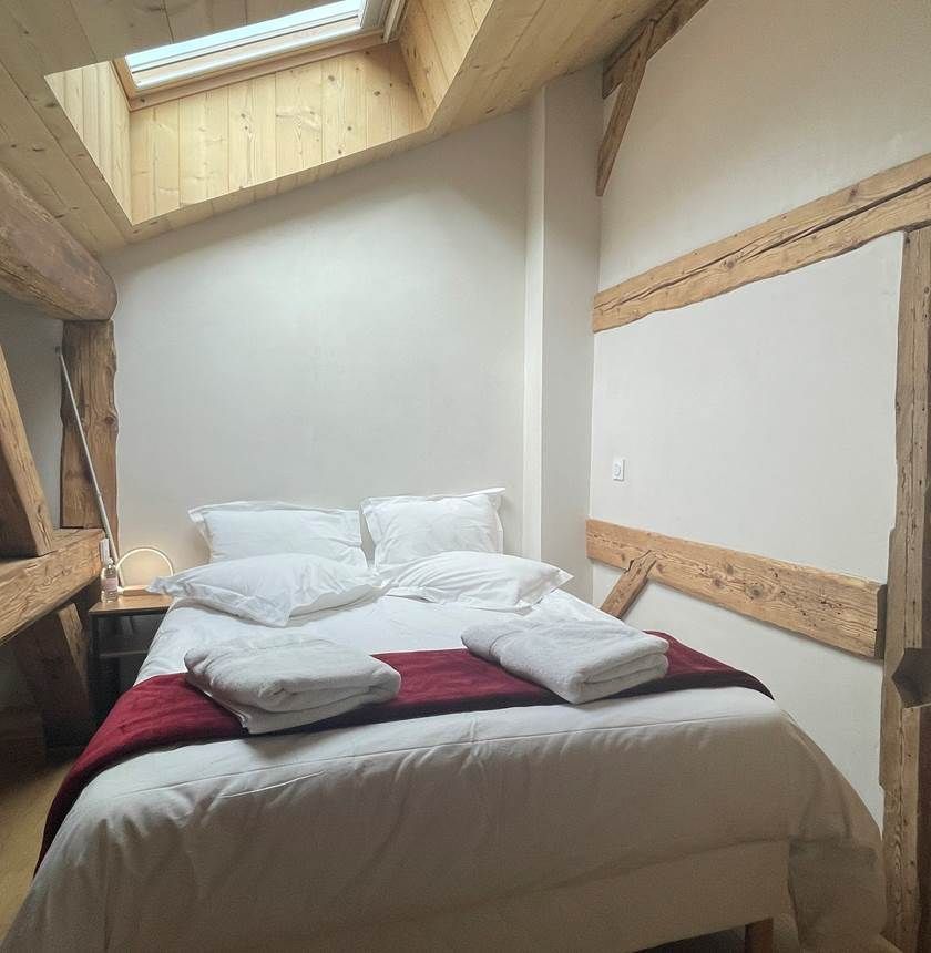 Vue d'une chambre individuelle standard avec fenêtre de toit et plafond mansardé.