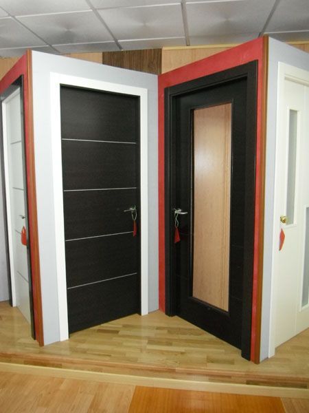 Un rincón de una habitación con dos puertas negras.