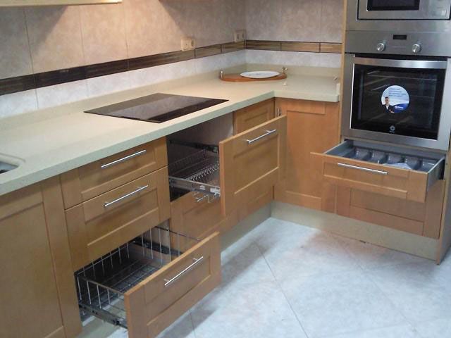 Una cocina con electrodomésticos de acero inoxidable y gabinetes de madera.