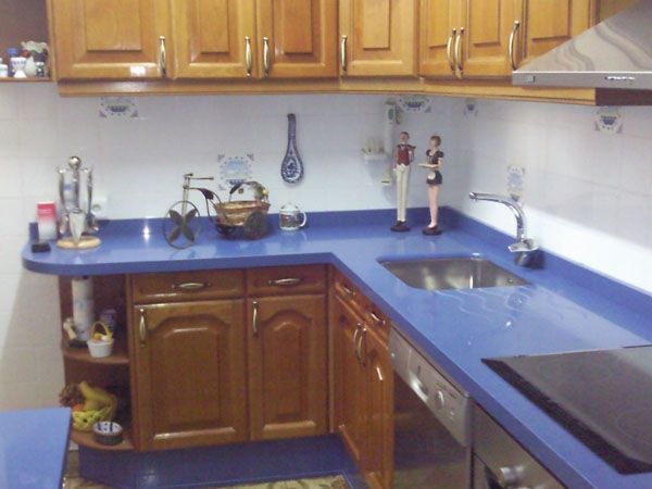 Una cocina con encimeras azules y gabinetes de madera.