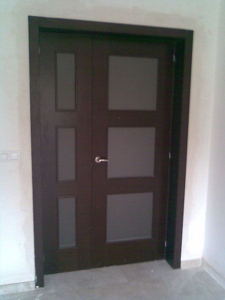 Una puerta marrón con cuadrados está en una habitación.