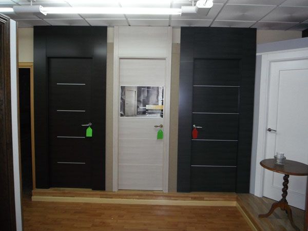 Una habitación con puertas blancas y negras y una mesa pequeña.