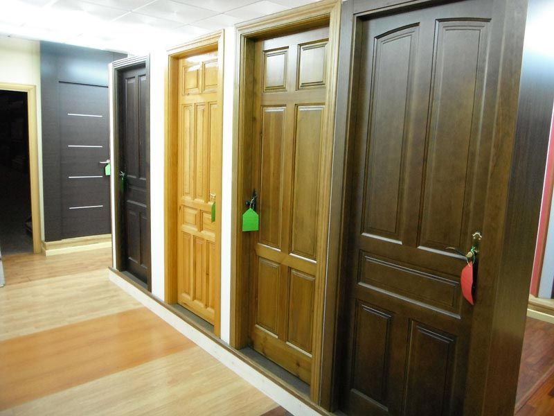 Una fila de puertas de madera están alineadas en un pasillo.