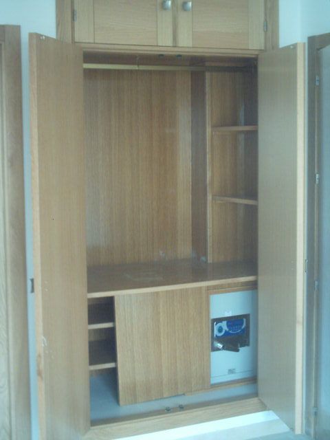 Un armario con las puertas abiertas y una caja fuerte dentro