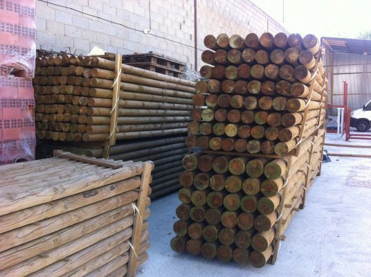 Un montón de postes de madera apilados uno encima del otro