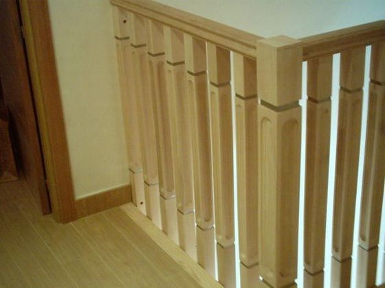 Una barandilla de madera en una escalera de una casa