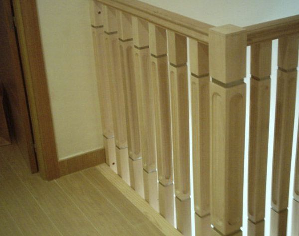 Una barandilla de madera en una escalera de una casa