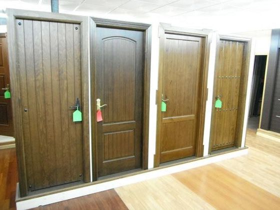 Una fila de puertas de madera con etiquetas verdes.